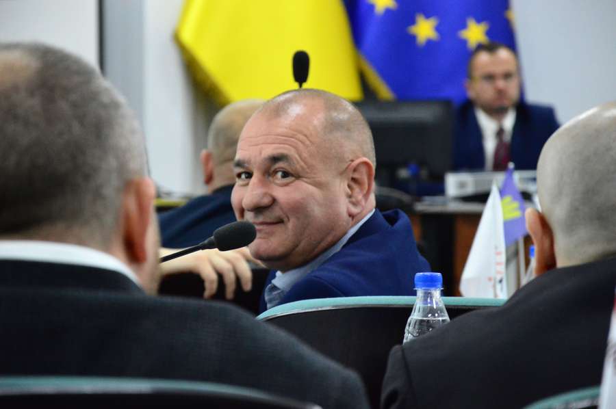 Аркадій Соломатін з посмішкою дивиться на Андрія Покровського після голосування по пайовій участі