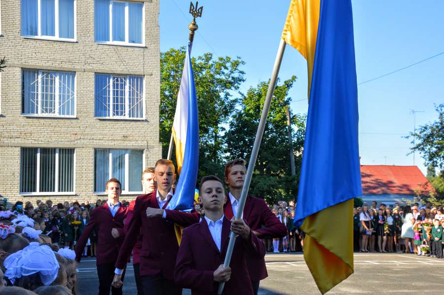 Хлопці бравим маршем пронесли подвір'ям школи українські прапори