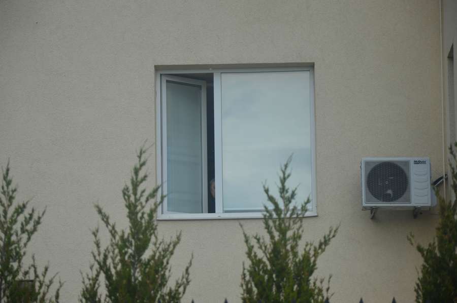 Із вікна на другому поверсі визирає чоловік, схожий на Вєслава Мазура. Помітивши камеру, він одразу сховався><span class=