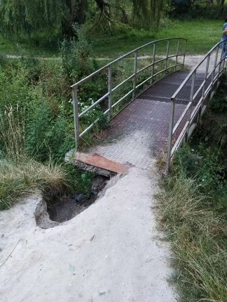 Величезна яма: у Луцьку просять відремонтувати аварійний міст у парку (фото)